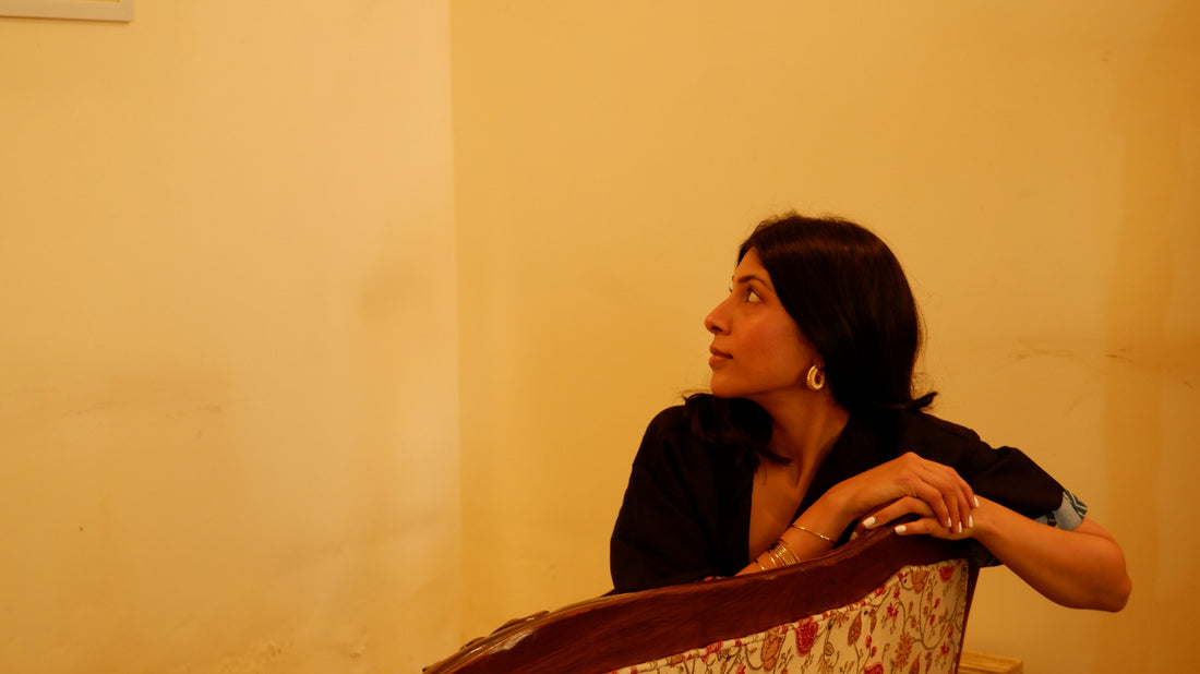 acid moons' founder Kareena Oberoi sitting on a sofa in soft ambient light